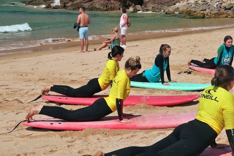 Group of surfers paddling out into the waves